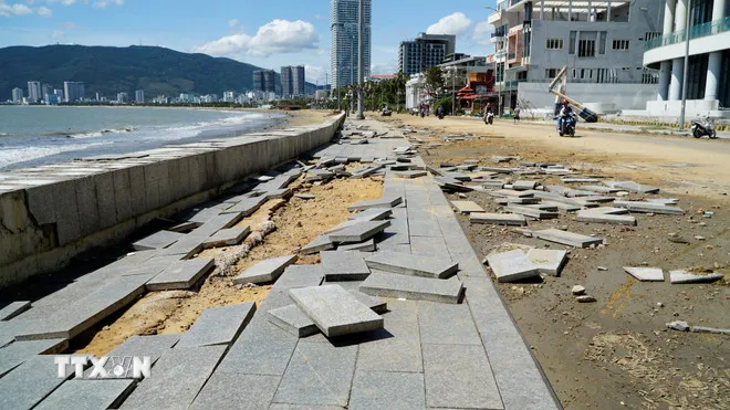 Vỉa hè bị sóng đánh lật từng mảng. (Ảnh: Đình Quân/TTXVN)