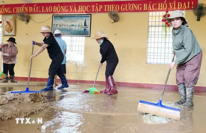 Trường Tiểu học và Trung học cơ sở Xuân Sơn Bắc (xã Đồng Xuân, Đắk Lắk) dọn dẹp sau bão lũ. (Ảnh: Tường Quân/TTXVN)
