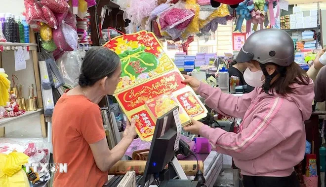 Người dân mua lịch năm mới. (Ảnh: Huyền Trang/TTXVN)