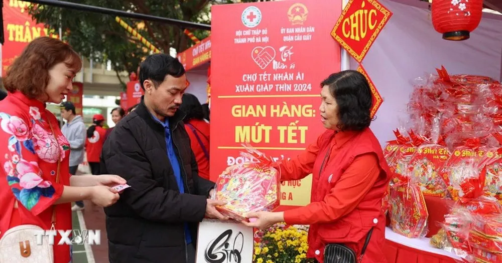 Người dân đổi phiếu để nhận hàng miễn phí tại các gian hàng ở Chợ Tết nhân ái Hà Nội. (Ảnh: Thanh Tùng/TTXVN) 