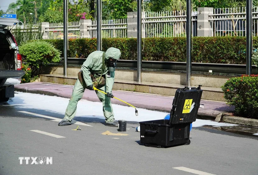 Lực lượng chức năng tiến hành thu hồi nguồn phóng xạ. (Ảnh: Thu Hoài/TTXVN) 