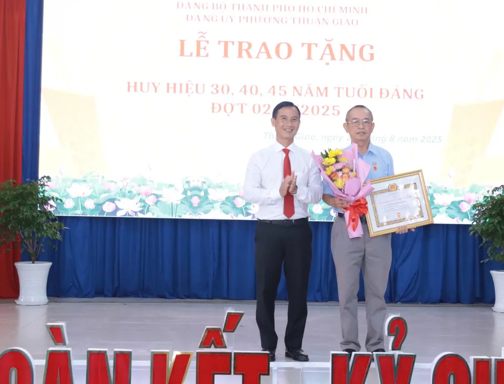 Đồng chí Nguyễn Thành Úy, Bí thư Đảng ủy phường Thuận Giao trao Huy hiệu Đảng cho đảng viên z6957184276054_542dbfe52ab73cf6c373a873980b0769.jpg