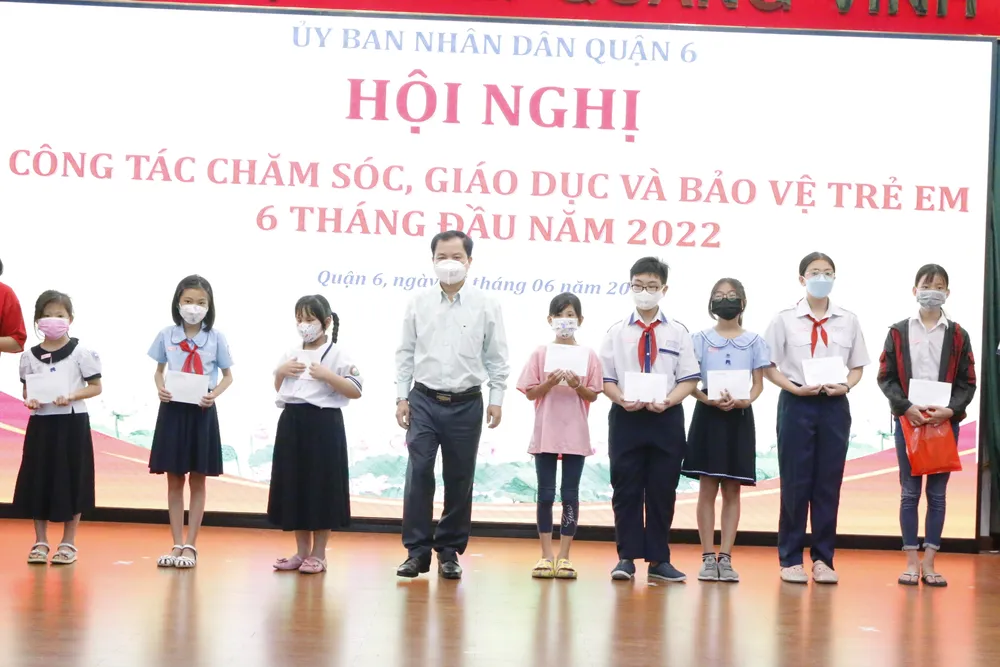 Bí thư Quận ủy quận 6 Ma Xuân Việt trao quà cho các em học sinh có hoàn cảnh khó khăn. Ảnh: VĂN MINH