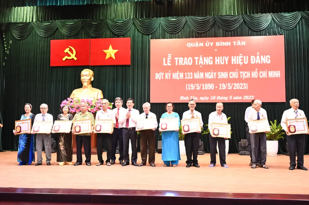 Chủ nhiệm Ủy ban Kiểm tra Thành ủy TPHCM Dương Ngọc Hải trao Huy hiệu Đảng. Ảnh: VĂN MINH