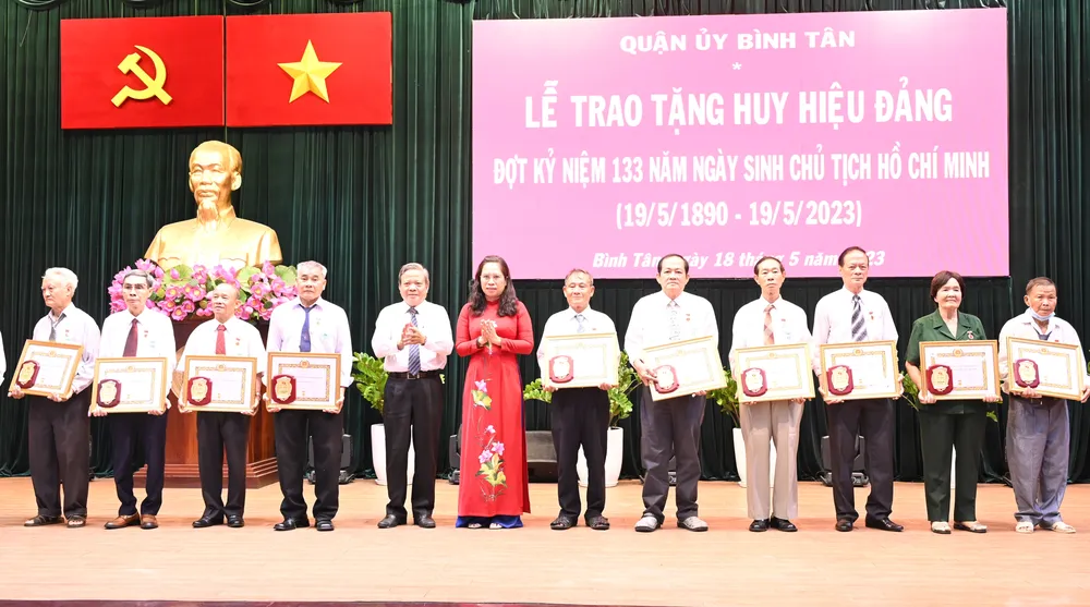 Chủ tịch Ủy ban MTTQ Việt Nam quận Bình Tân Lê Văn Bảy và Trưởng Ban Tuyên giáo Quận ủy quận Bình Tân Nguyễn Thị Bé Hai trao Huy hiệu Đảng. Ảnh: VĂN MINH