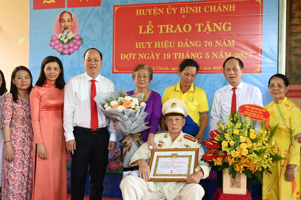 Phó Bí thư Thành ủy TPHCM Nguyễn Hồ Hải trao Huy hiệu 70 năm tuổi Đảng đến đồng chí Đinh Văn Lưu. Ảnh: VĂN MINH