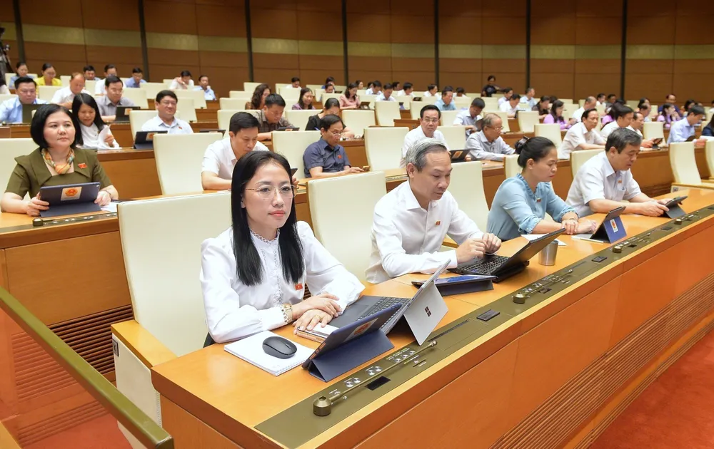 Đại biểu Quốc hội theo dõi Bộ trưởng Bộ Quốc phòng trình bày tờ trình. Ảnh: QUANG PHÚC