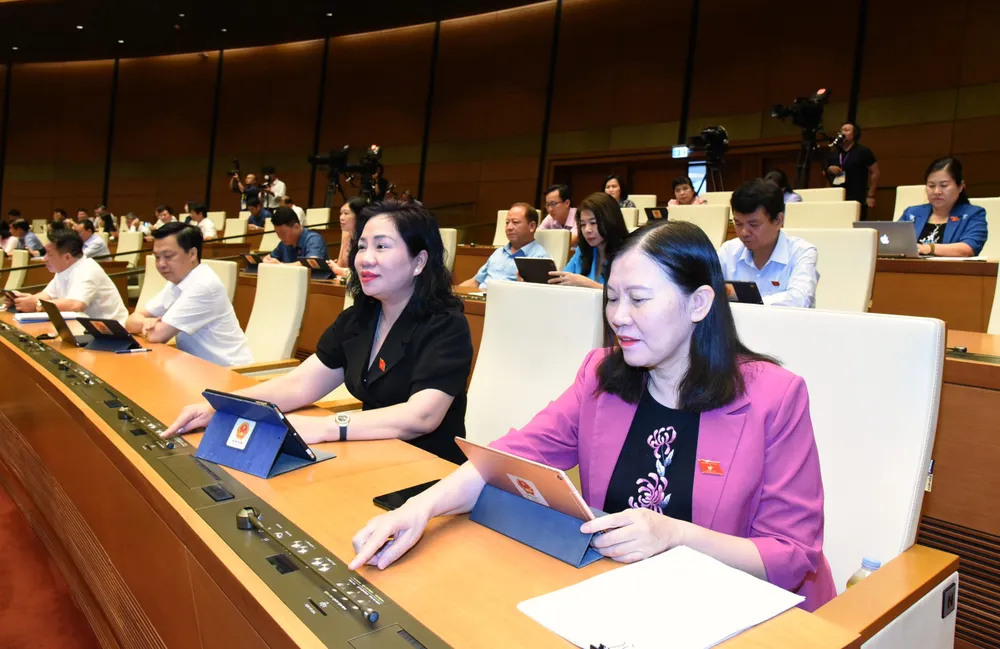 Đại biểu Quốc hội bấm nút thông qua nghị quyết. Ảnh: QUANG PHÚC