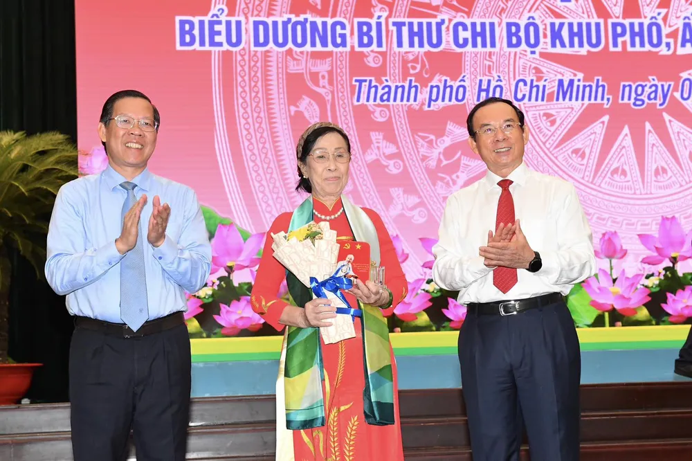 Bí thư Thành ủy TPHCM Nguyễn Văn Nên và Chủ tịch UBND TPHCM Phan Văn Mãi trao biểu trưng và hoa trong lễ biểu dương. Ảnh: VIỆT DŨNG