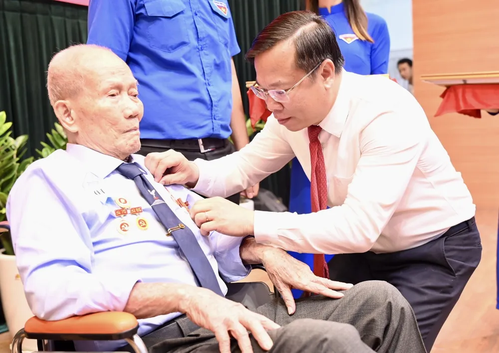 Bí thư Quận ủy quận Bình Tân Huỳnh Khắc Điệp trao Huy hiệu Đảng. Ảnh: VĂN MINH