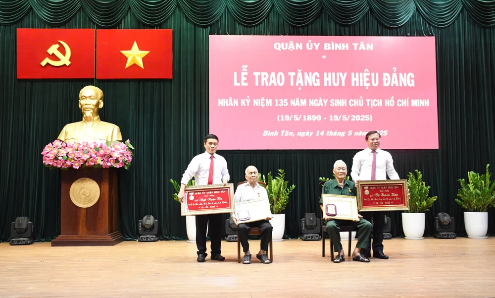 Bí thư Quận ủy quận Bình Tân Huỳnh Khắc Điệp và Chủ tịch UBND quận Bình Tân Nguyễn Trung Anh trao Huy hiệu Đảng. Ảnh: LÊ AN 8e561a49e42f5171083e.jpg