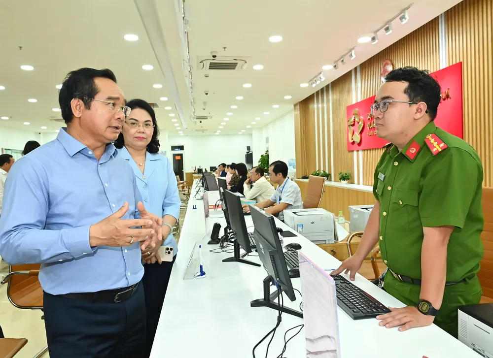 Chủ tịch UBND TPHCM Nguyễn Văn Được trao đổi với cán bộ công an đang trực tại Bộ phận cấp, trả thẻ căn cước. Ảnh: VIỆT DŨNG 71ec3441a36a17344e7b.jpg