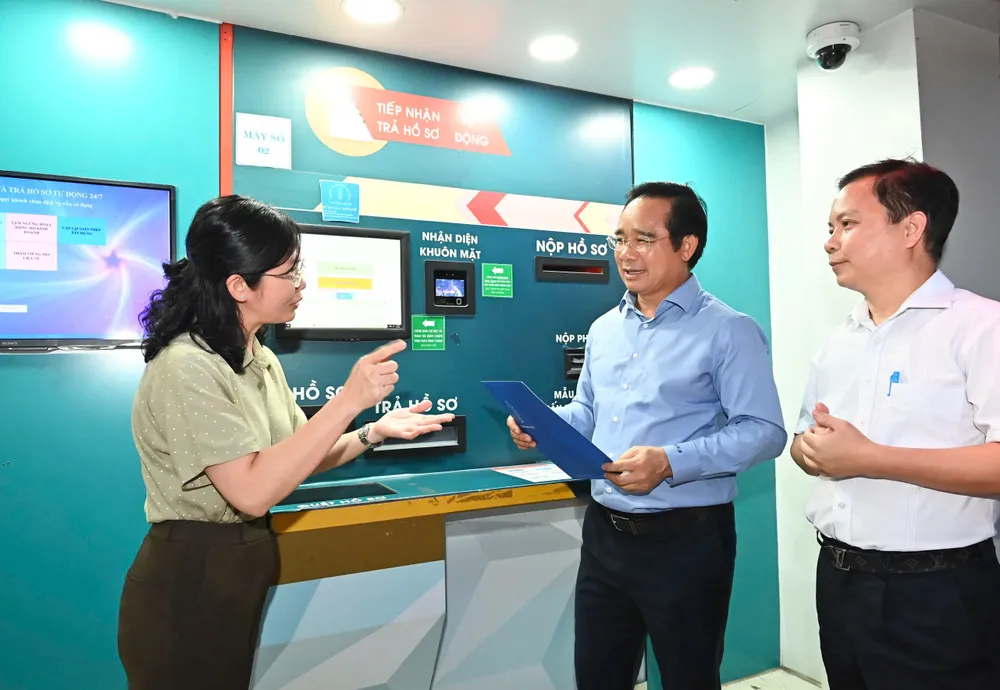 Lãnh đạo quận 6 giới thiệu cây ATM tiếp nhận và trả hồ sơ tự động 24/7. Ảnh: VIỆT DŨNG 9fd64d6eda456e1b3754.jpg