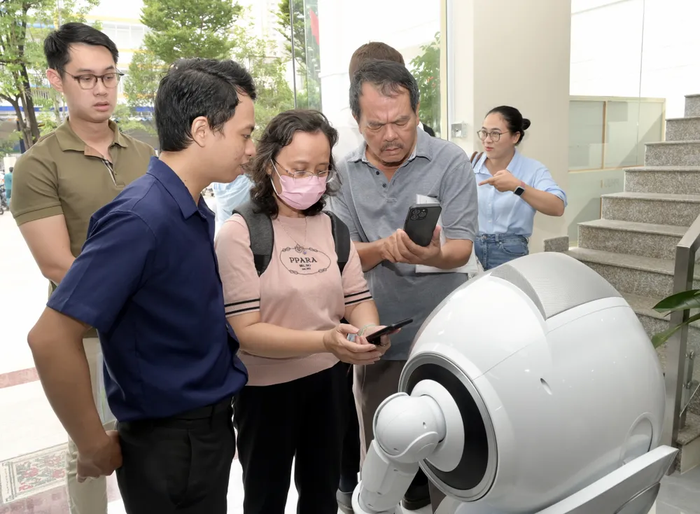 Người dân đến làm thủ tục hành chính được robot hướng dẫn. Ảnh: VĂN MINH DSC_3093.jpeg