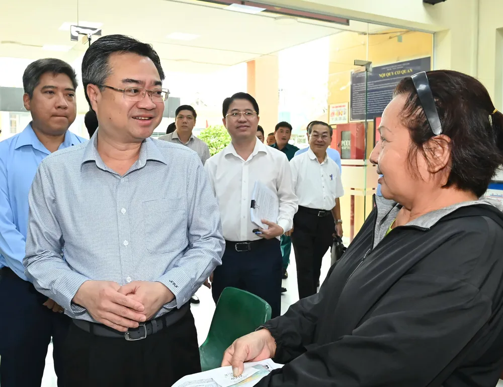 Đồng chí Nguyễn Thanh Nghị hỏi thăm người dân đến làm thủ tục hành chính tại Trung tâm Phục vụ hành chính công phường Bình Hưng Hòa. Ảnh: VIỆT DŨNG f31b8b424309ca579318.jpg