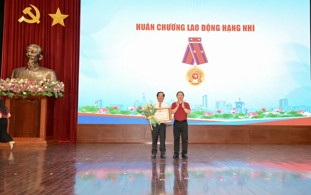 Đồng chí Dương Anh Đức trao Huân chương Lao động hạng Nhì và tặng hoa chúc mừng đồng chí Trần Văn Khuyên. Ảnh: VĂN MINH DSC_0629.jpeg
