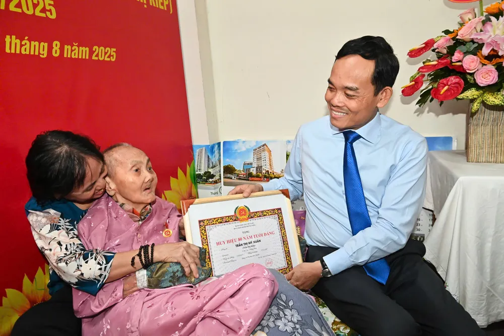 Bí thư Thành ủy TPHCM Trần Lưu Quang trao tặng Huy hiệu 80 năm tuổi Đảng đến đồng chí Trần Thị Mỹ Xuân. Ảnh: VIỆT DŨNG 52c79d7065c2ed9cb4d3.jpg