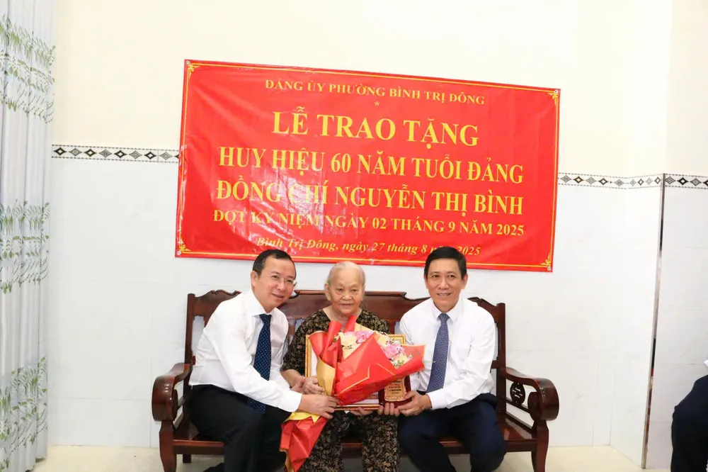 Phó Trưởng Ban Tổ chức Thành ủy TPHCM Đặng Quốc Toàn và Bí thư Đảng ủy, Chủ tịch HĐND phường Bình Trị Đông Trần Xuân Điền trao Huy hiệu 60 năm tuổi Đảng đến đồng chí Nguyễn Thị Bình 3614083354422325388.jpg