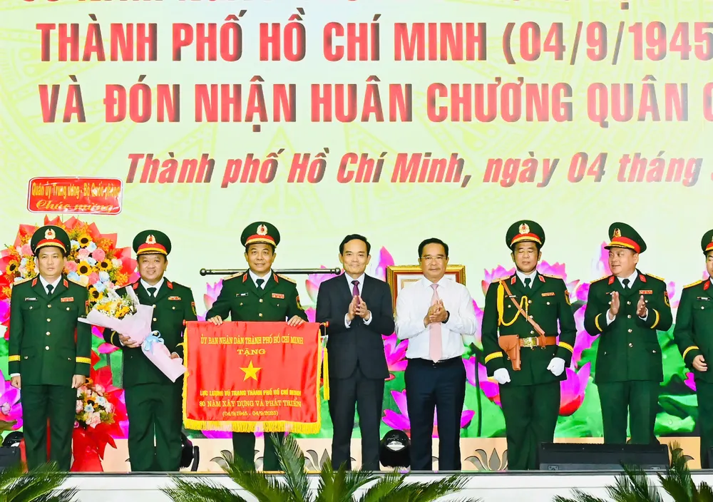 Bí thư Thành ủy TPHCM Trần Lưu Quang và Chủ tịch UBND TPHCM Nguyễn Văn Được trao Cờ truyền thống cho Lực lượng vũ trang TPHCM. Ảnh: VIỆT DŨNG 3457314799735368897(1).jpg