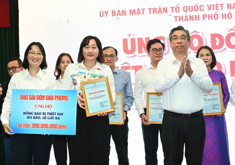 Đại diện Báo Sài Gòn Giải Phóng, Phó Tổng Biên tập Bùi Thị Hồng Sương trao bảng tượng trưng ủng hộ 300 triệu đồng. Ảnh: VIỆT DŨNG ba8231eb6c5ee600bf4f.jpg