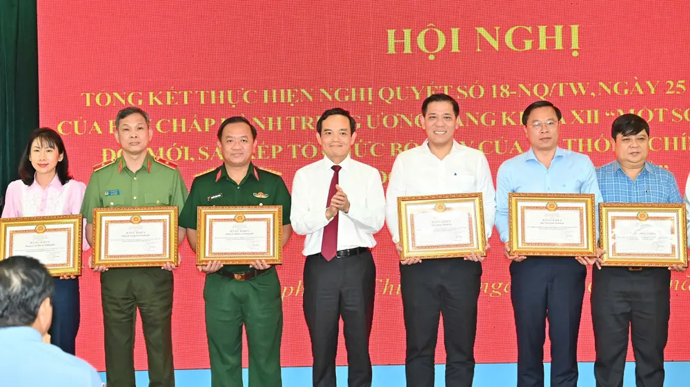 Bí thư Thành ủy TPHCM Trần Lưu Quang trao bằng khen cho các tập thể, cá nhân có thành tích xuất sắc trong việc thực hiện Nghị quyết 18. Ảnh: VIỆT DŨNG gen-h-z7143190853158_bf4e8cba528acf34008bd9ab29eaf00e.jpg