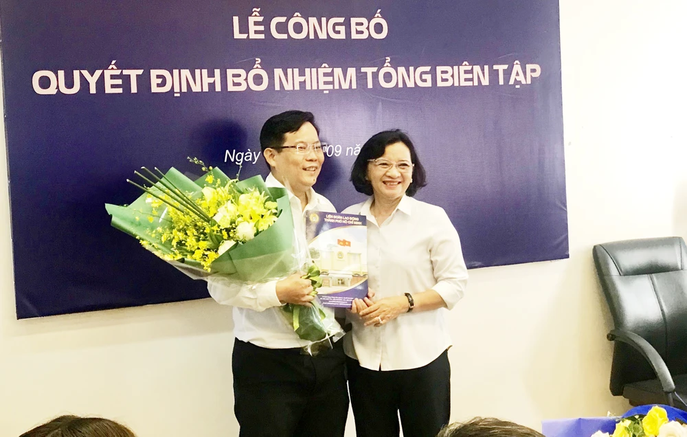 Đồng chí Thân Thị Thư, Trưởng Ban Tuyên giáo Thành ủy TPHCM, tặng hoa chúc mừng tân Tổng Biên tập Báo Người Lao động Tô Đình Tuân. Ảnh: KIỀU PHONG