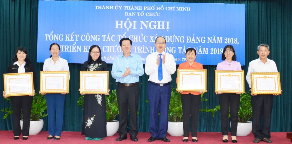 Bí thư Thành ủy TPHCM Nguyễn Thiện Nhân và Phó Trưởng Ban Tổ chức Trung ương Mai Văn Chính, chúc mừng các tập thể được nhận bằng khen. Ảnh: KIỀU PHONG