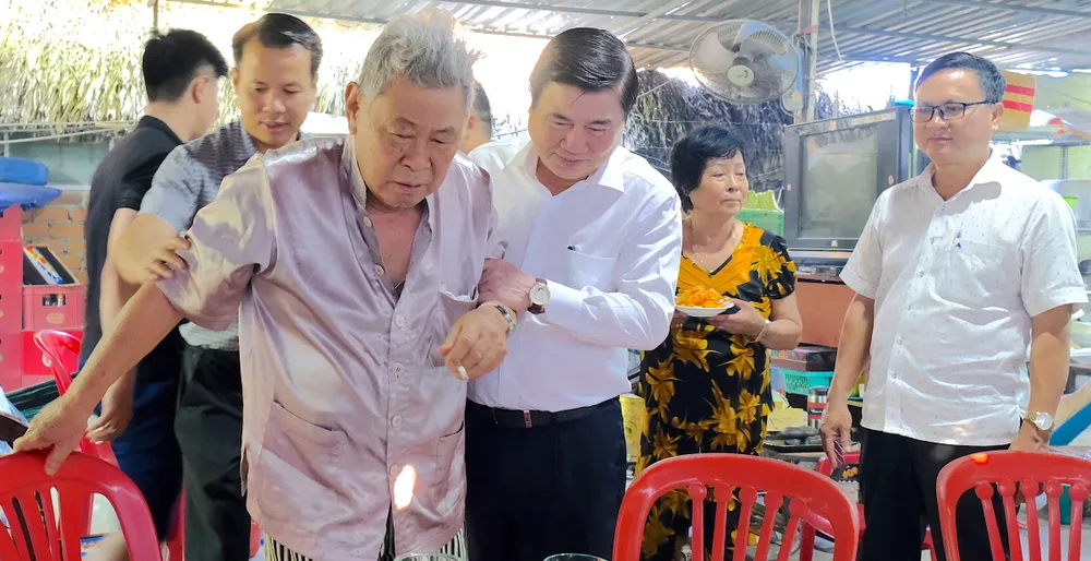 Chủ tịch UBND TPHCM ân cần thăm hỏi sức khỏe ông Huỳnh Quang Hải và gia đình ông. Ảnh: KIỀU PHONG