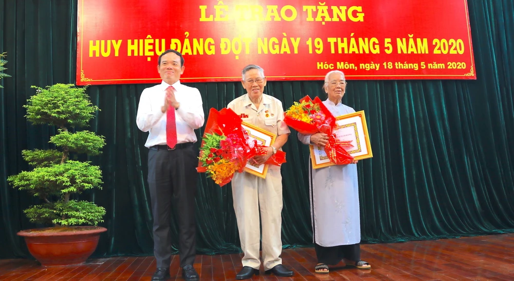  Đồng chí Trần Lưu Quang, Phó Bí thư Thường trực Thành ủy TPHCM trao Huy hiệu Đảng cho đảng viên cao tuổi Đảng thuộc Đảng bộ huyện Hóc Môn, sáng 18-5-2020. Ảnh: ANH CHÂU