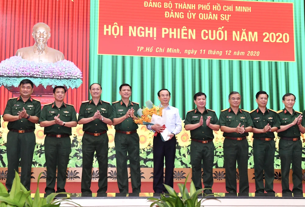 Bí thư Thành ủy TPHCM Nguyễn Văn Nên nhận hoa chúc mừng giữ chức vụ Bí thư Đảng ủy Quân sự TPHCM, sáng 11-12-2020. Ảnh: VIỆT DŨNG