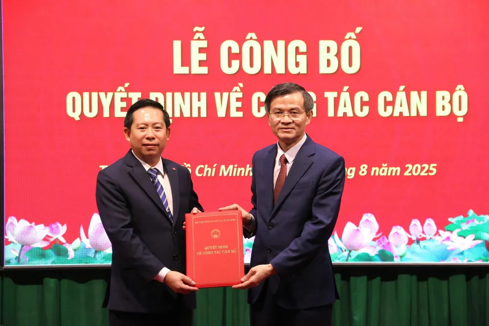 PGS.TS Đoàn Minh Huấn (phải), Phó Giám đốc Thường trực Học viện Chính trị quốc gia Hồ Chí Minh trao quyết định bổ nhiệm PGS.TS Nguyễn Tấn Vinh làm Giám đốc Học viện Chính trị khu vực II Thầy Huấn trao cho thầy Vinh.jpg