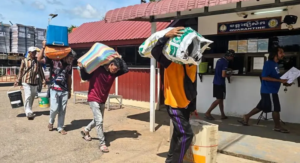 Lao động người Campuchia vận chuyển hàng qua biên giới tại trạm kiểm soát Phnom Dey, tỉnh Battambang, Campuchia. Ảnh: NATIONAL TELEVISION CAMBODIA Cam.jpg