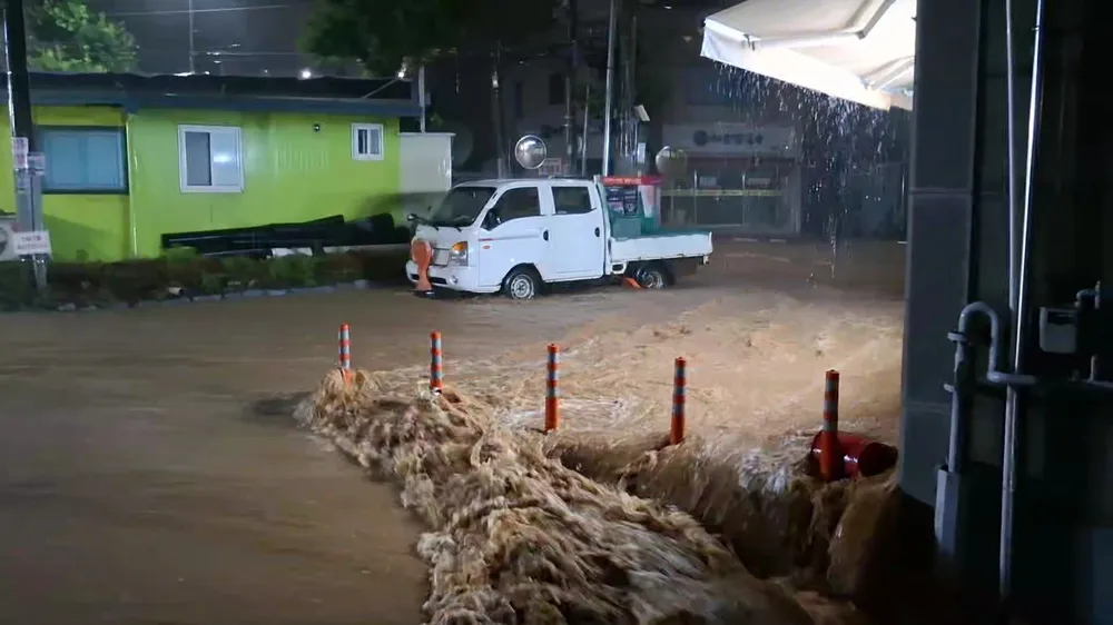 Nước cuộn đục ngầu ở TP Seosan, Hàn Quốc ngày 17-7. Ảnh: YONHAP HQ 1.jpg