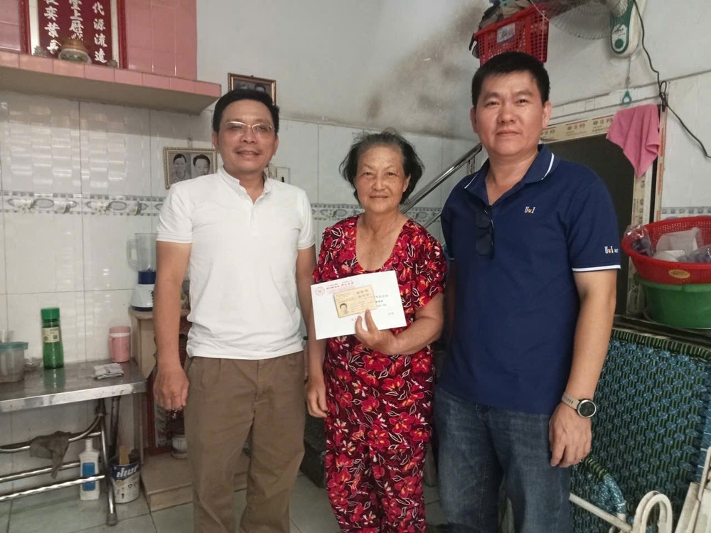 何俊昌理事长(左)和何民刚常值副理事长(右)向何小萍宗亲移交善款。