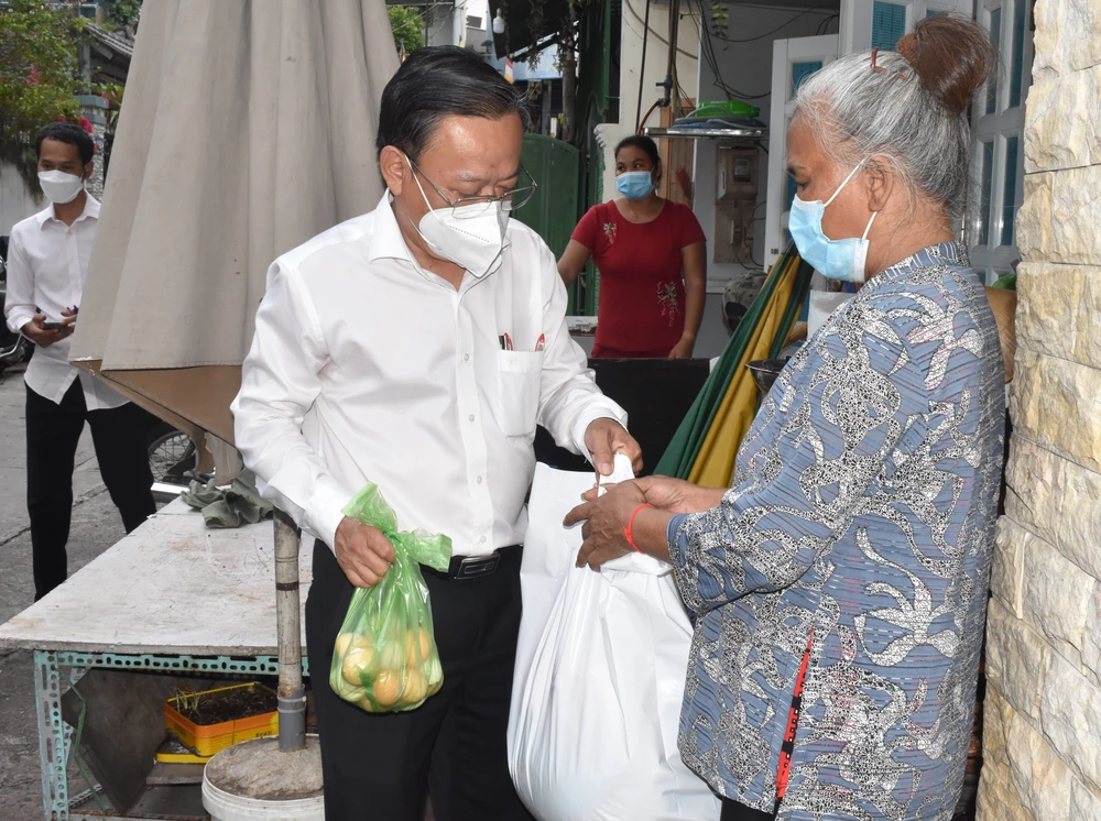 Trưởng Ban Dân vận Thành ủy TPHCM Nguyễn Hữu Hiệp tặng quà một số hộ dân đồng bào dân tộc có hoàn cảnh khó khăn ở quận Tân Bình. Ảnh: ĐÌNH LÝ