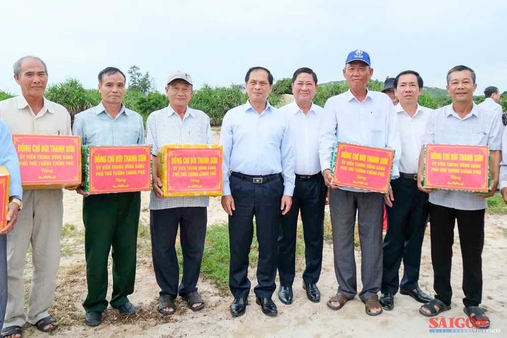 Phó Thủ tướng Bùi Thanh Sơn tặng quà cho người dân trong vùng dự án. Ảnh: HIẾU GIANG dasua-1.jpg