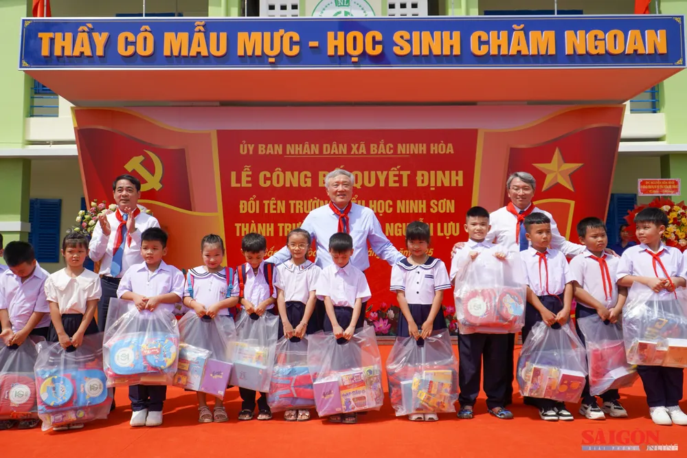 Đồng chí Nguyễn Hòa Bình tặng quà cho các em học sinh. Ảnh: HIẾU GIANG 12.jpg