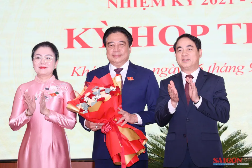 Bí thư Tỉnh ủy Khánh Hòa Nghiêm Xuân Thành (bìa phải) tặng hoa chúc mừng ông Nguyễn Khắc Toàn. Ảnh: HIẾU GIANG dasua-.jpg