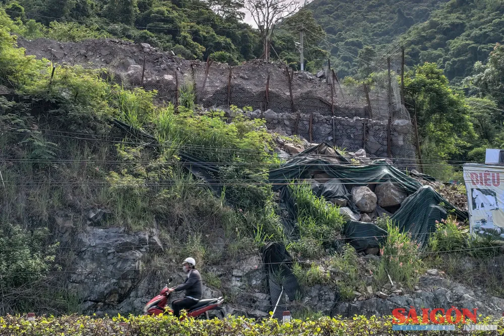 Những khối đá lớn cùng bờ taluy từ trên cao khiến người đi đường lo ngại nguy cơ sạt lở. Ảnh: HIẾU GIANG dasua-.jpg