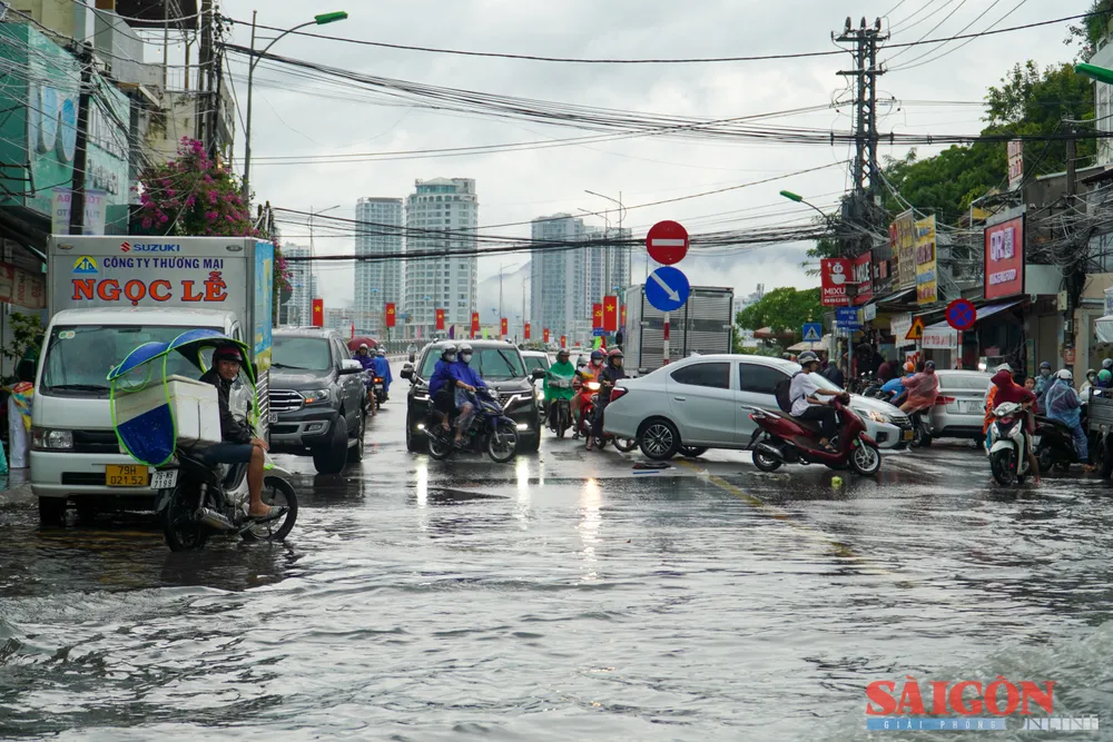 Nhiều người dân vội vã điều khiển xe quay lại, sau khi thấy cả đoạn đường bị ngập sâu. Ảnh: HIẾU GIANG dasua-00551.jpg