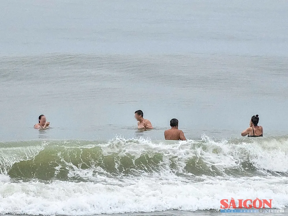Dù sóng lớn, một số du khách bất chấp cảnh báo, lội ra vùng nước sâu để tắm. Ảnh: HIẾU GIANG dasua-9.jpg