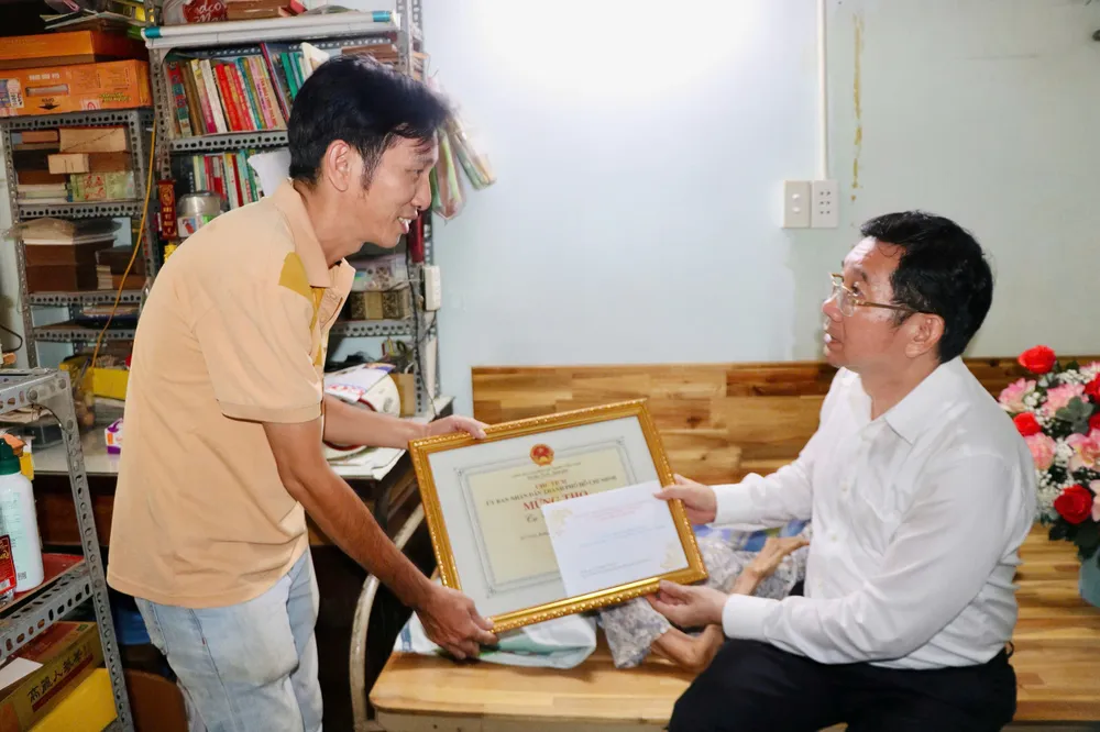 Phó Chủ tịch Thường trực UBND TPHCM Dương Ngọc Hải gửi các phần quà cho gia đình bà Trần Ý Linh. Ảnh: CẨM NƯƠNG z6675270853252_4bac86edb0c23ecc7f09993098ede950.jpg