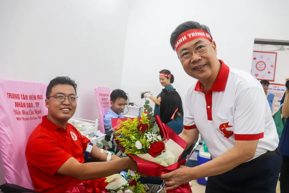 PGS.TS Nguyễn Hà Thanh tặng hoa cho cá nhân tham gia hiến máu, sáng 25-6 z6739684129994_4b8999e8dbaa7799fe91212138d5cb3f.jpg
