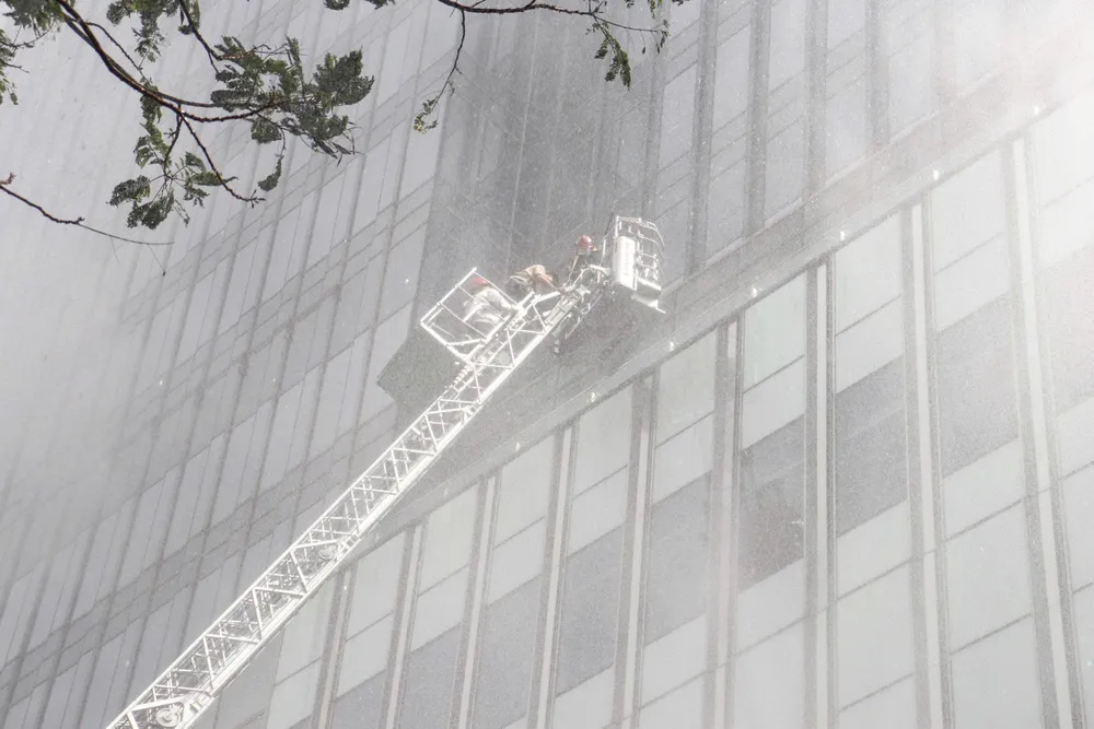 Sử dụng xe thang cứu người mắc kẹt ở tầng cao. Ảnh: CẨM TUYẾT z7173814552696_fc7f173f4d41f8d477f9d38100780508.jpg