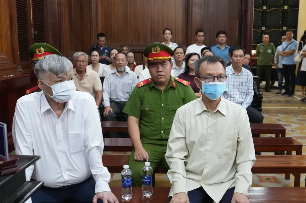 Bị cáo Nguyễn Công Khế (trái) và Nguyễn Quang Thông (phải) tại phiên tòa sơ thẩm sáng 29-10. Ảnh: KIM THỨC 1406e1e2ad4c2012795d.jpg