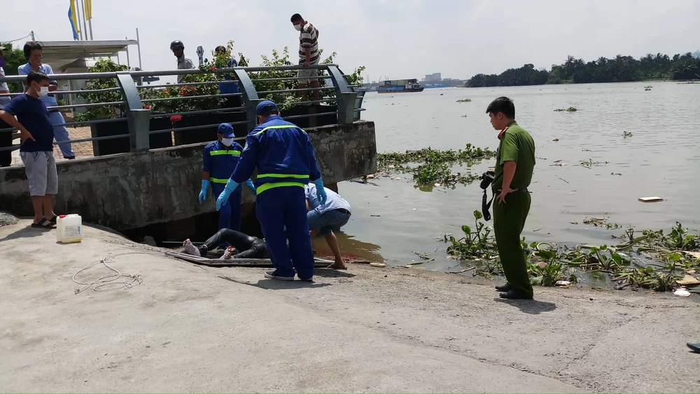 Công an đưa thi thể vào bờ để khám nghiệm. Ảnh: ĐAN NGUYÊN