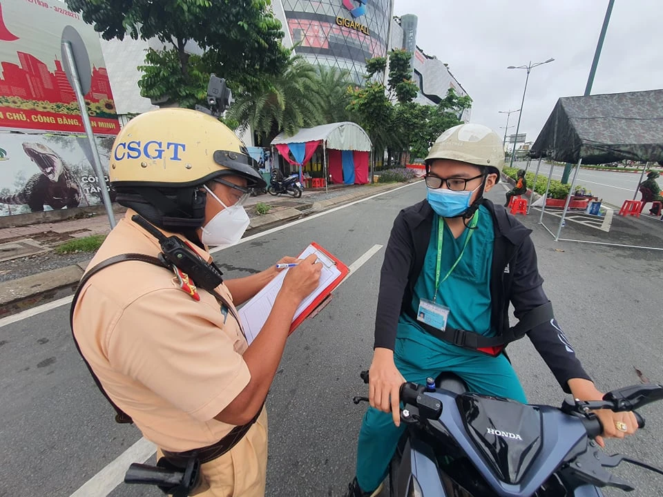 Lực lượng chức năng kiểm tra người dân tham gia lưu thông trên đường. Ảnh: CHÍ THẠCH 