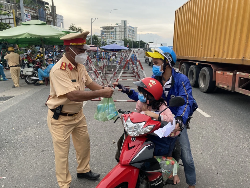 CSGT TPHCM hỗ trợ nước, sữa, khẩu trang... cho người dân trên đường về miền Tây 