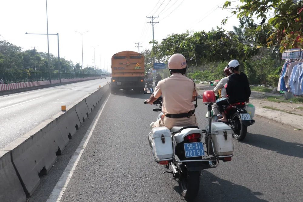 CSGT TPHCM phối hợp cùng nhân viên quét dọn hút “đinh tặc” cho người dân về quê ăn tết. Ảnh: M.V.