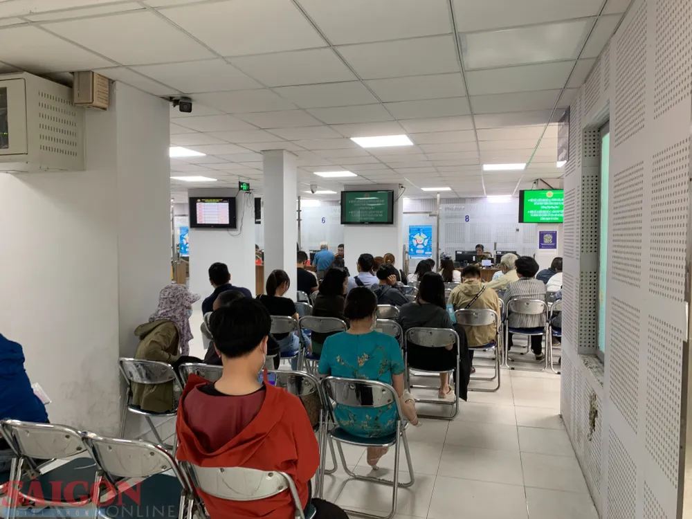 Người dân ngồi chờ làm thủ tục cấp hộ chiếu tại Phòng PA08. Ảnh: CHÍ THẠCH